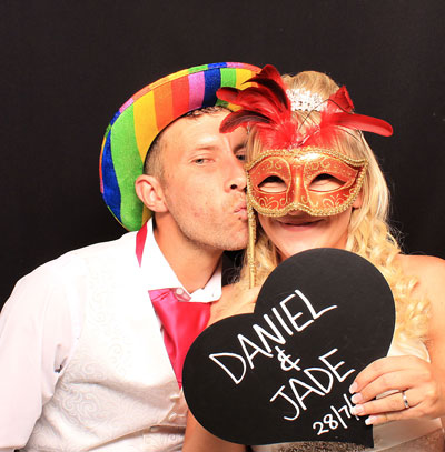 couple in the photo booth with love heart board