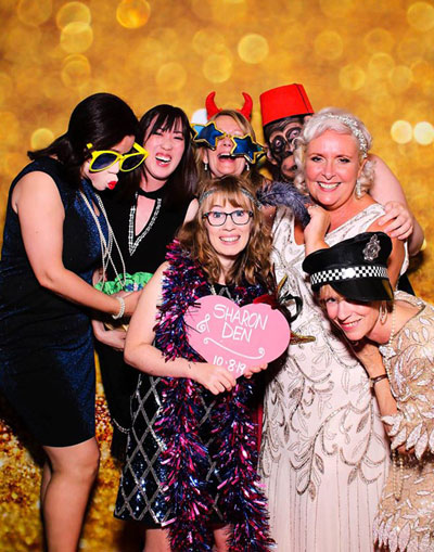 Ladies using photo booth with lovely gold background